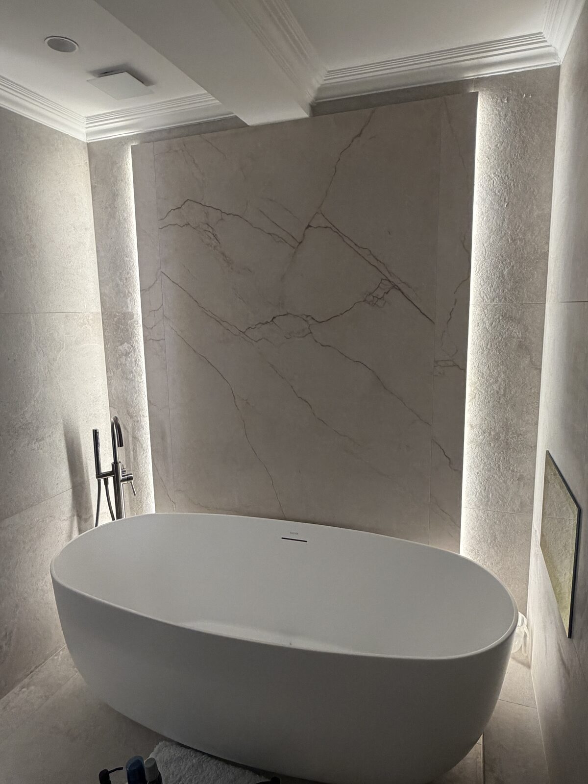 Freestanding bath against a backlit marble feature wall, Harrogate